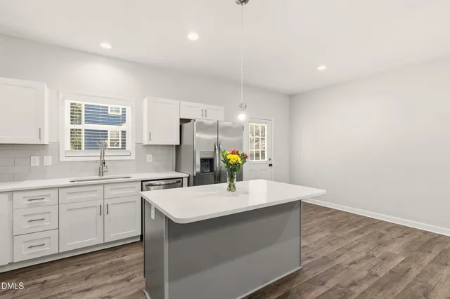 a kitchen with a sink cabinets and wooden floor
