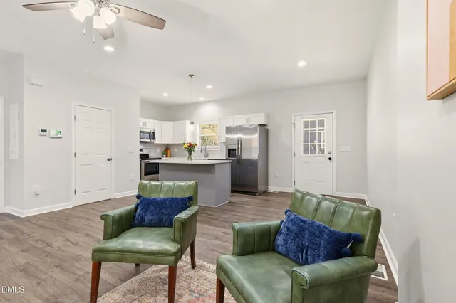 a view of dining room and livingroom with furniture wooden floor a chandelier