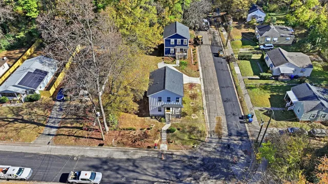 a view of a white house with a large tree
