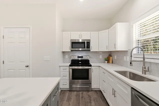 a kitchen with stainless steel appliances a refrigerator and a stove top oven