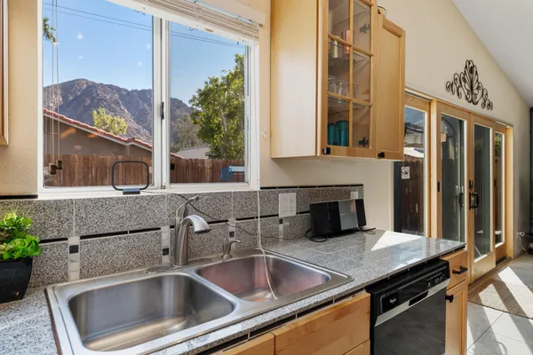 a living room with stainless steel appliances kitchen island granite countertop a stove and a refrigerator
