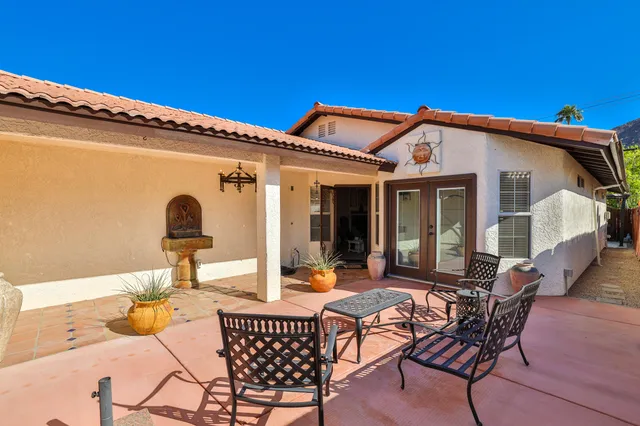 a view of a patio with table and chairs and potted plants