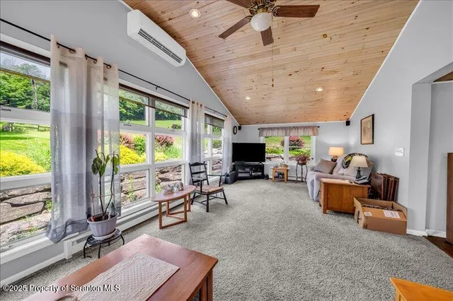 a living room with furniture a flat screen tv and a large window