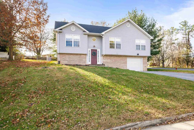 a view of a yard in front of a house with large trees