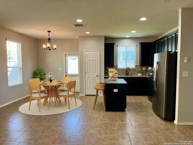 a kitchen with a refrigerator and a dining table