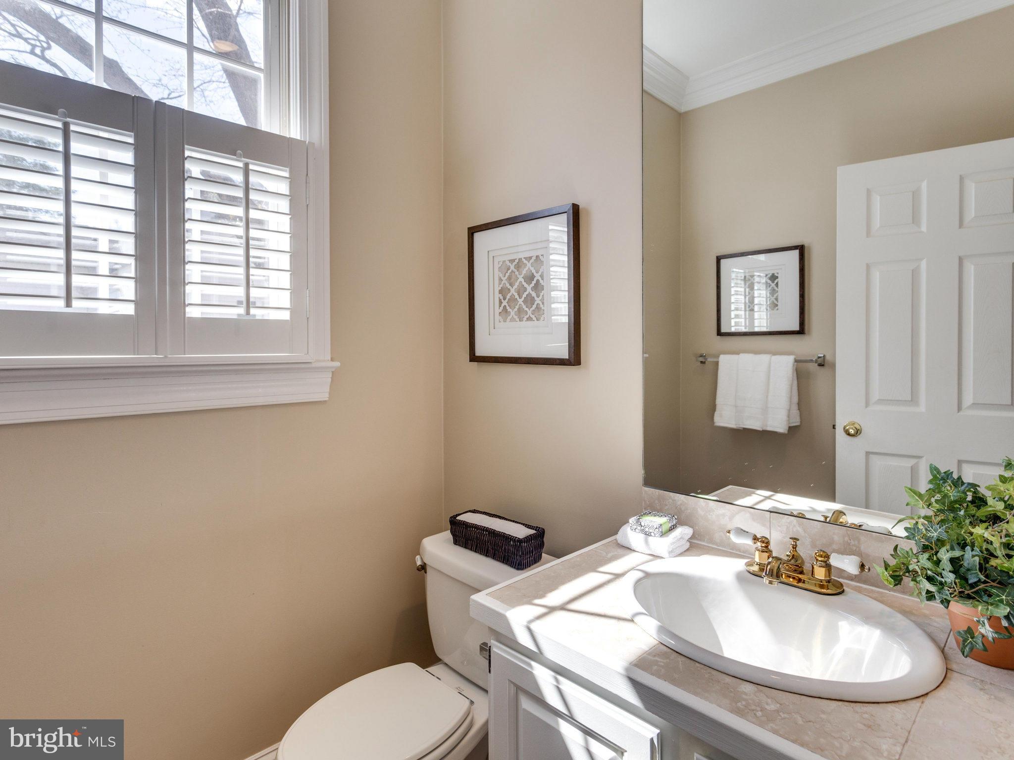 9423 Seven Locks Road Bethesda, MD 20817 - Photo 13 of 28 a bathroom with a granite countertop toilet and a mirror