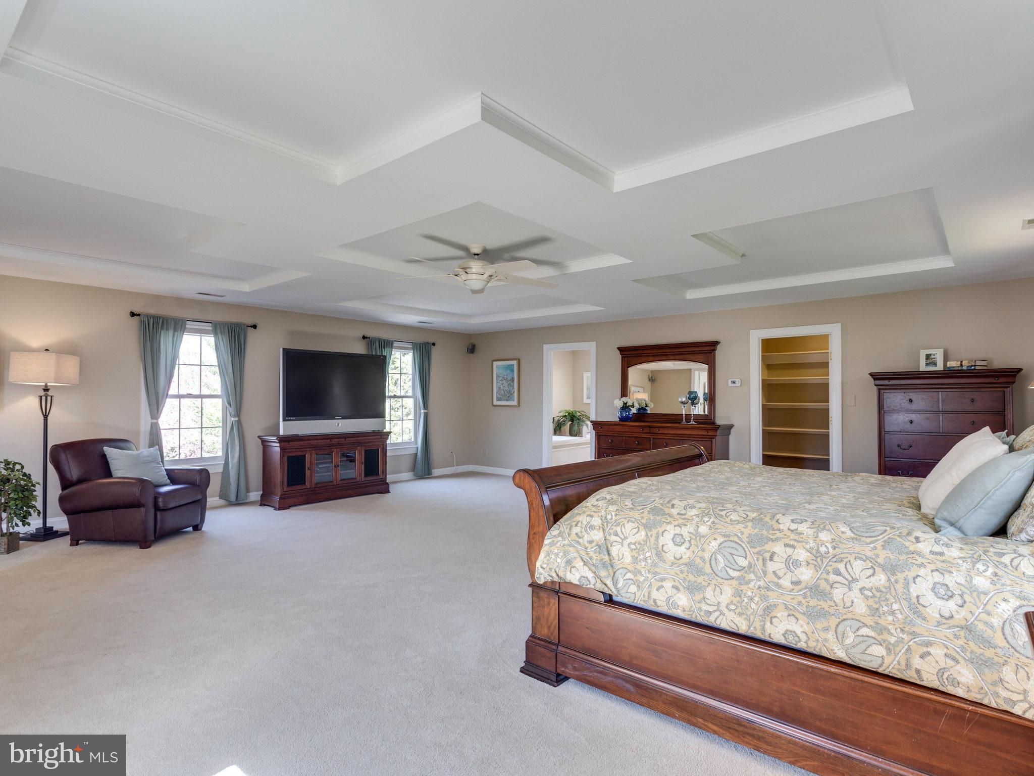 9423 Seven Locks Road Bethesda, MD 20817 - Photo 15 of 28 a bedroom with a large bed a flat tv screen and a couch