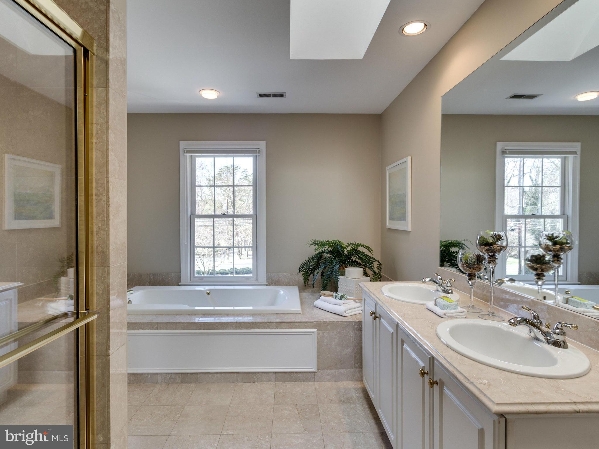 9423 Seven Locks Road Bethesda, MD 20817 - Photo 17 of 28 a bathroom with a double vanity sink tub and mirror