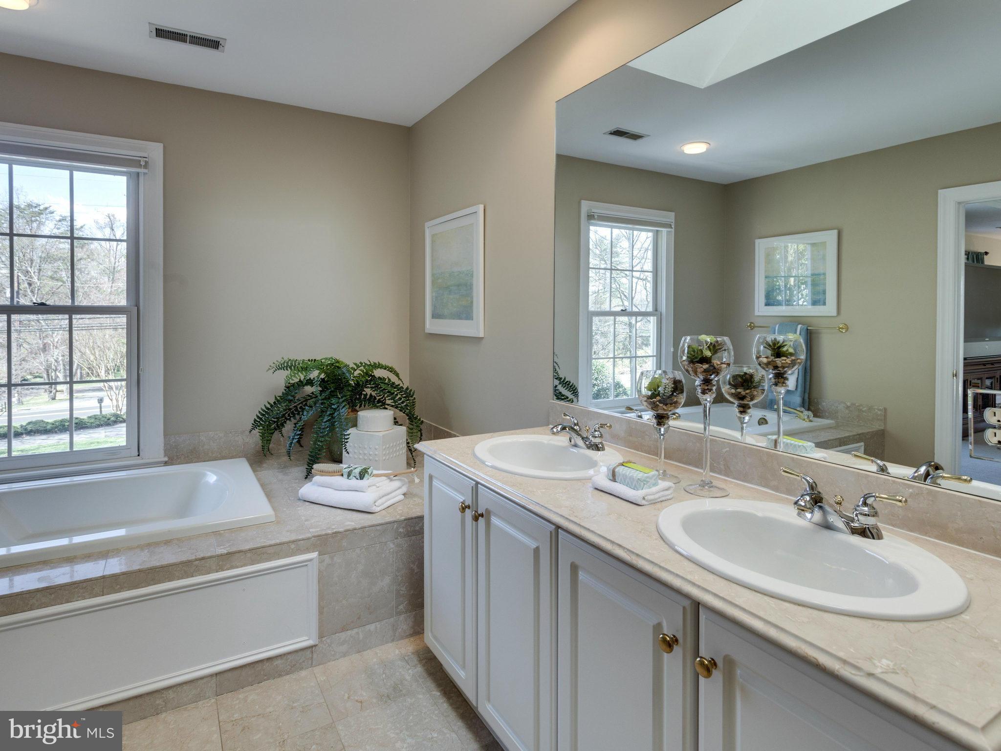 9423 Seven Locks Road Bethesda, MD 20817 - Photo 18 of 28 a bathroom with a granite countertop sink mirror and a bathtub