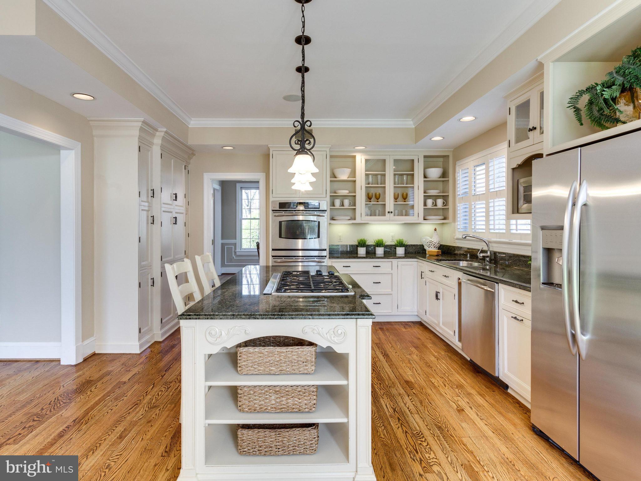 9423 Seven Locks Road Bethesda, MD 20817 - Photo 9 of 28 a kitchen with stainless steel appliances granite countertop a stove a sink dishwasher a refrigerator white cabinets and wooden floor next to a window