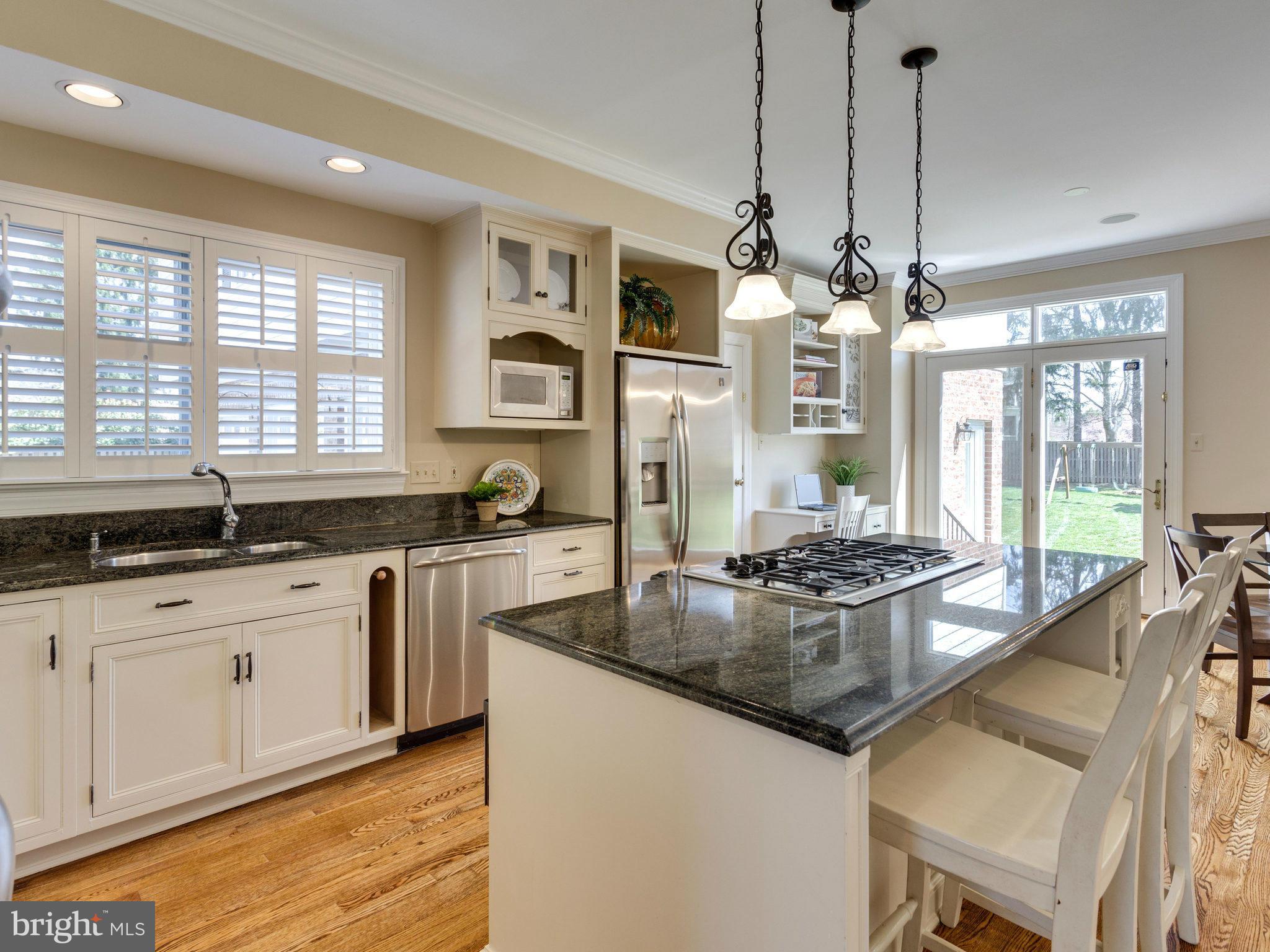 9423 Seven Locks Road Bethesda, MD 20817 - Photo 10 of 28 a kitchen with stainless steel appliances granite countertop a stove a sink a chimney a refrigerator and a granite counter tops