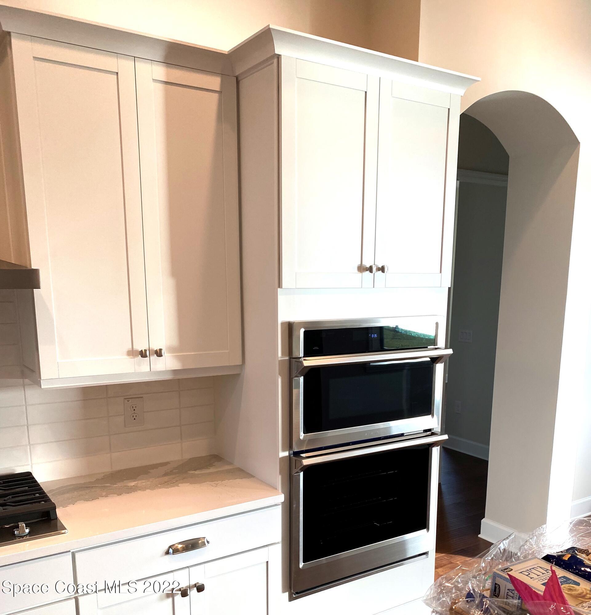 8321 Paragrass Avenue Melbourne, FL 32940 - Photo 11 of 41 a kitchen with granite countertop white cabinets and appliances
