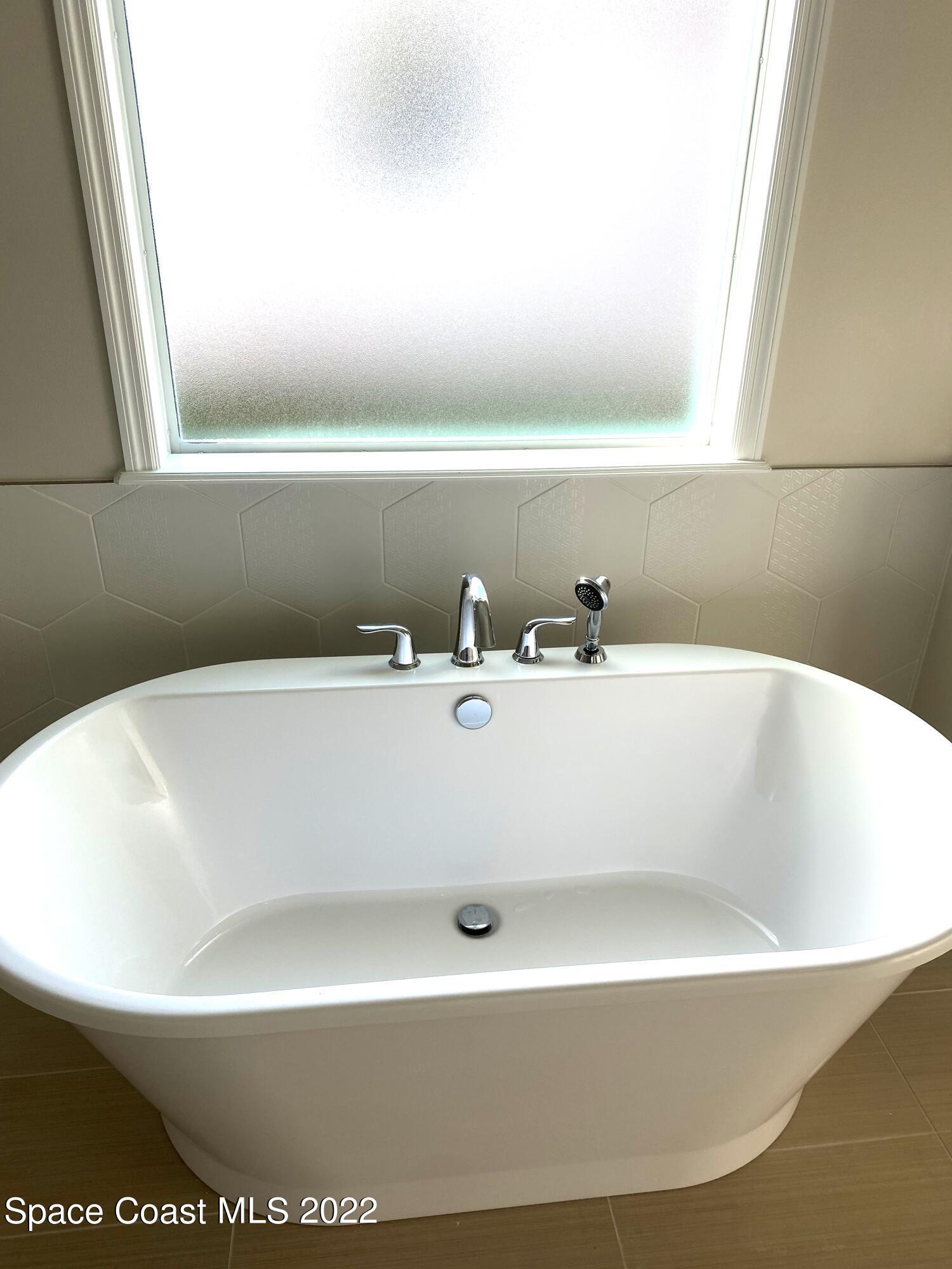 8321 Paragrass Avenue Melbourne, FL 32940 - Photo 20 of 41 a white bath tub sitting in a bathroom
