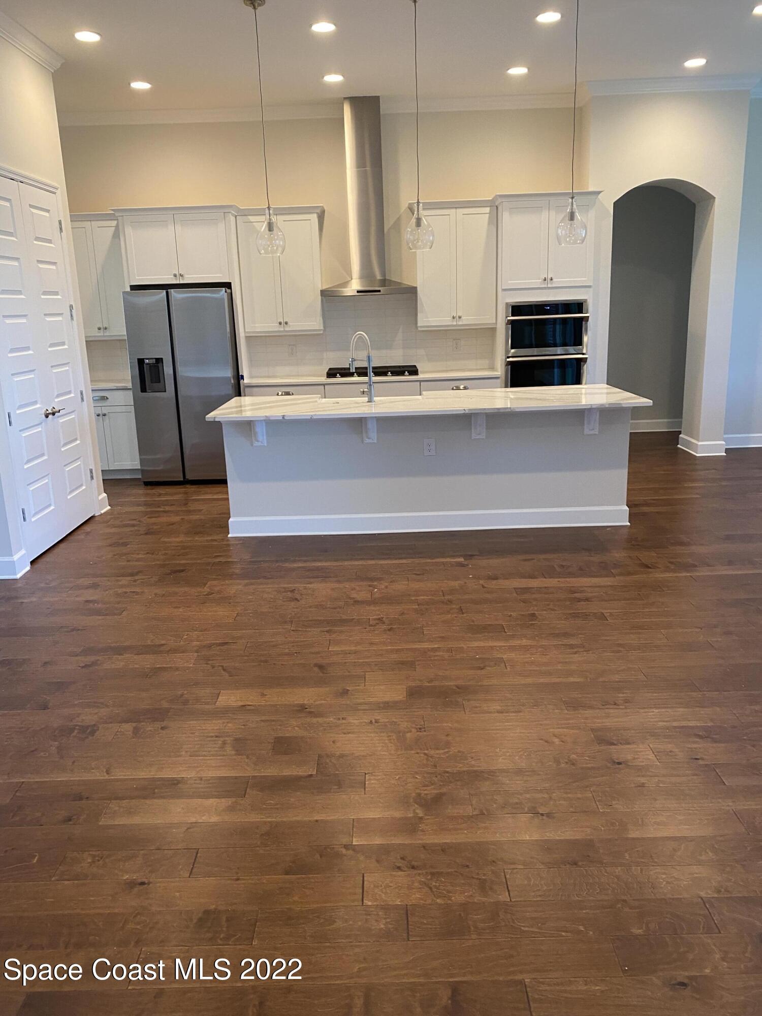 8321 Paragrass Avenue Melbourne, FL 32940 - Photo 2 of 41 a large kitchen with stainless steel appliances a large counter top and a stove top oven