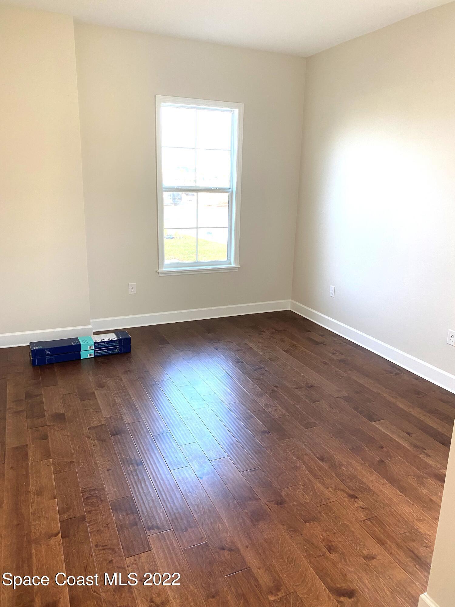 8321 Paragrass Avenue Melbourne, FL 32940 - Photo 24 of 41 an empty room with wooden floor and windows