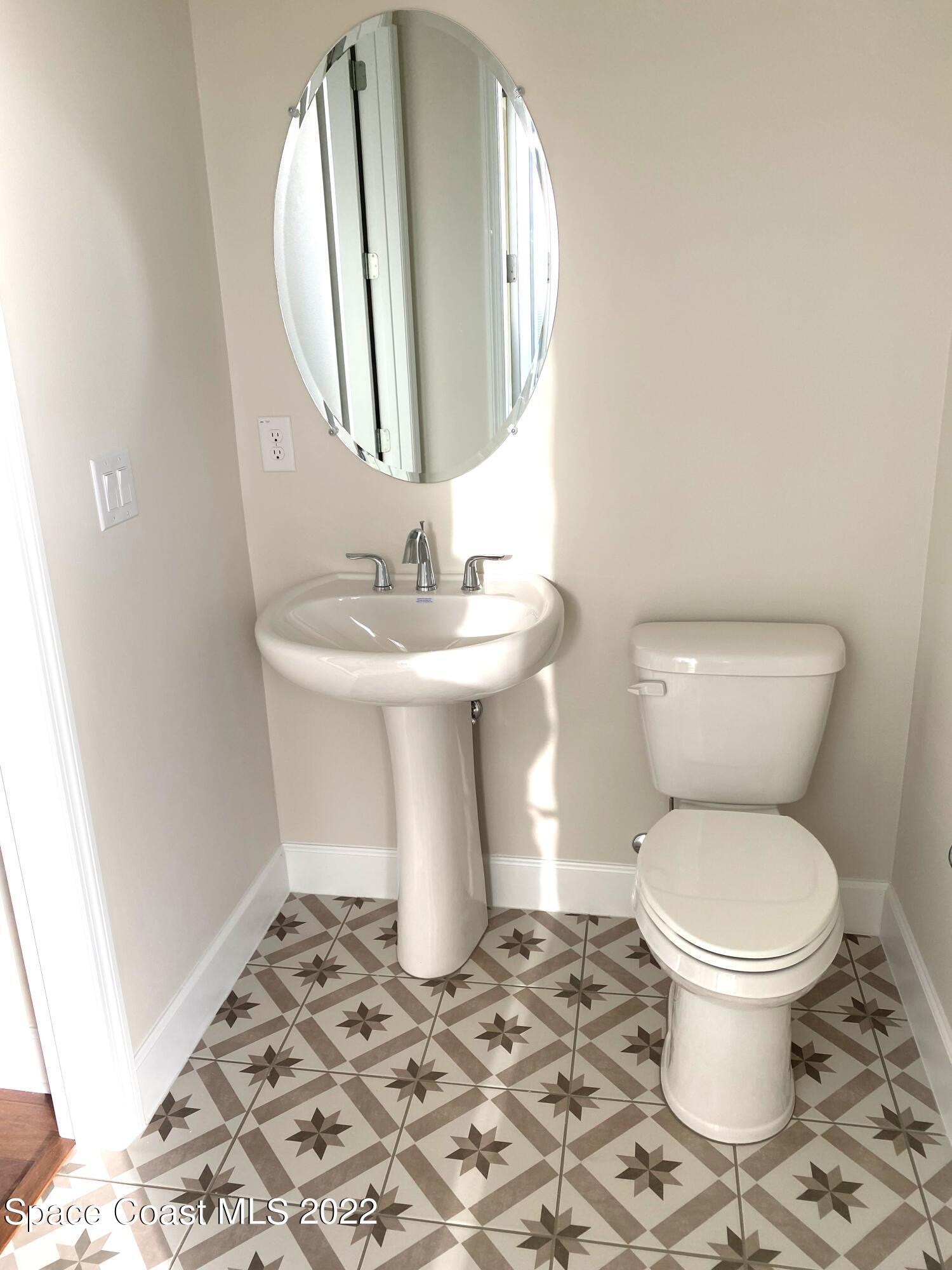 8321 Paragrass Avenue Melbourne, FL 32940 - Photo 26 of 41 a white toilet sitting next to a bathroom sink