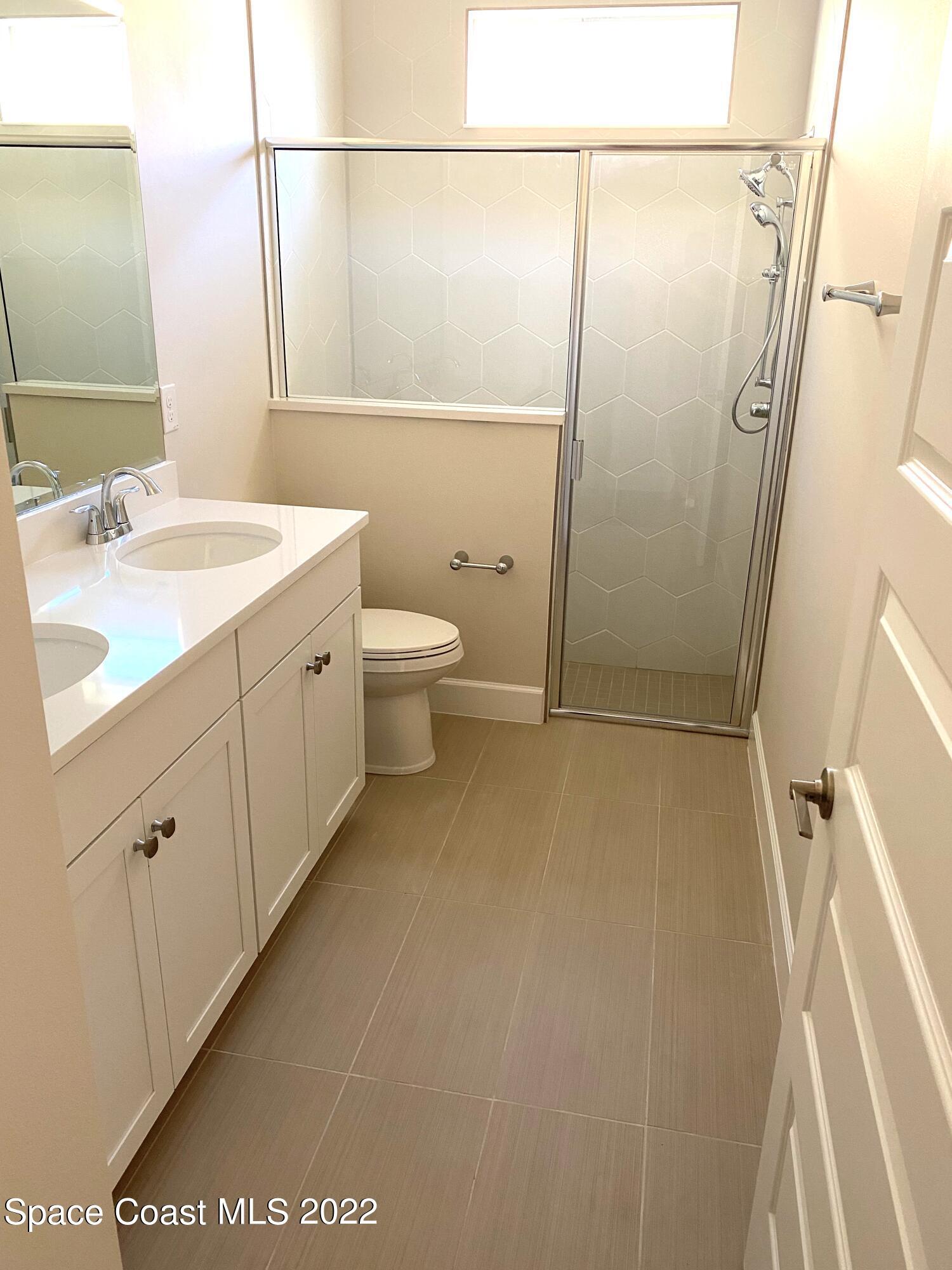 8321 Paragrass Avenue Melbourne, FL 32940 - Photo 28 of 41 a bathroom with a granite countertop sink toilet and shower