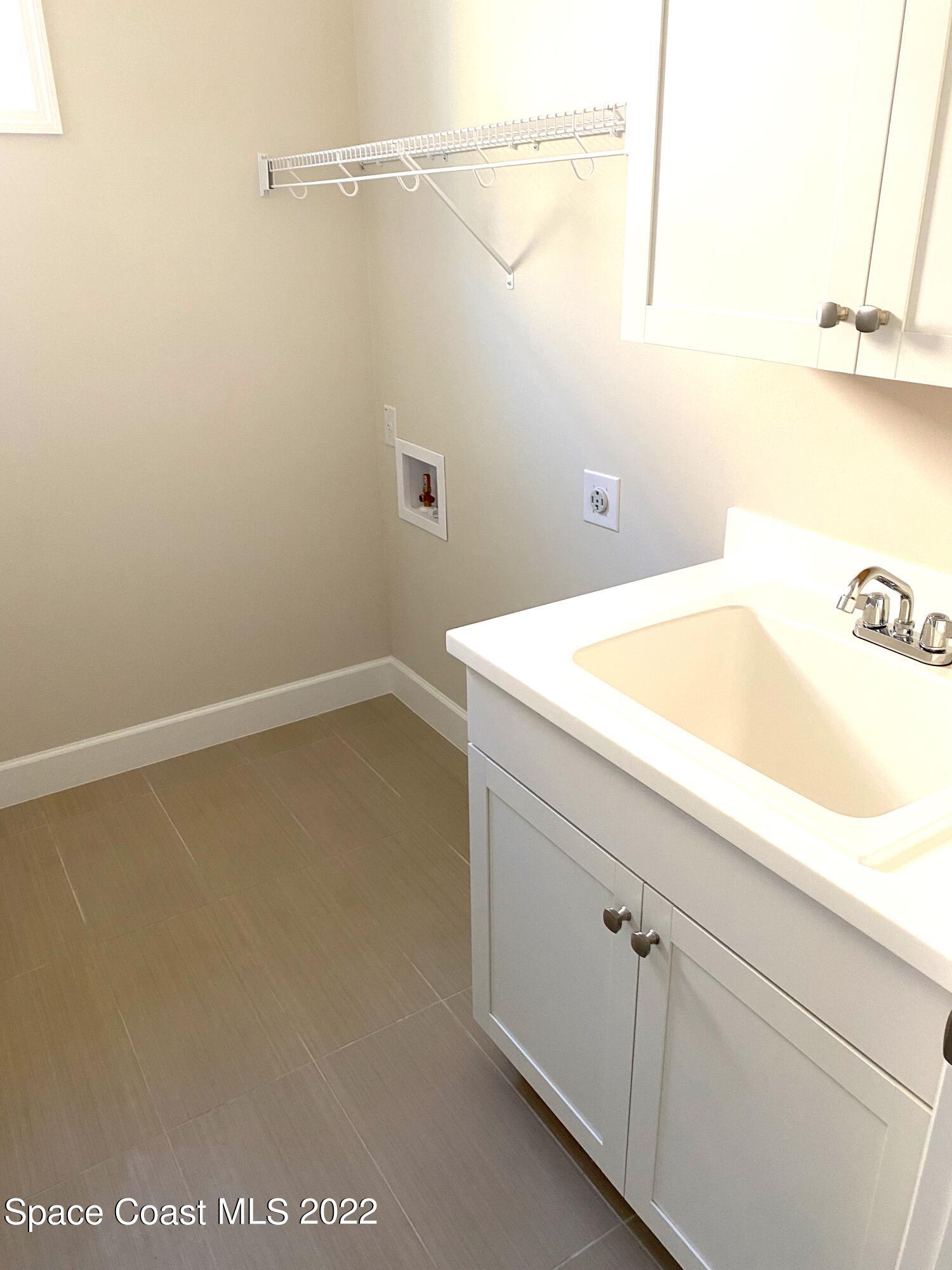 8321 Paragrass Avenue Melbourne, FL 32940 - Photo 29 of 41 a bathroom with a sink and vanity