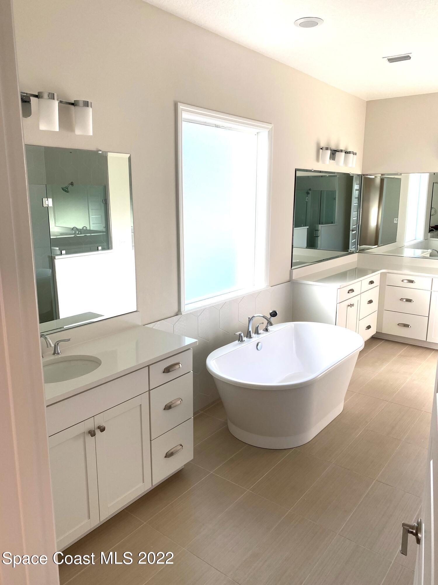 8321 Paragrass Avenue Melbourne, FL 32940 - Photo 3 of 41 a bathroom with a bathtub a mirror and sink