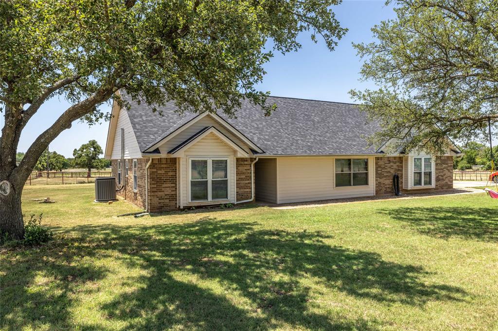 151 County Road 3699 Springtown, TX 76082 - Photo 2 of 35 Single-story residence featuring brick and siding exterior, a dark shingle roof, and multiple windows