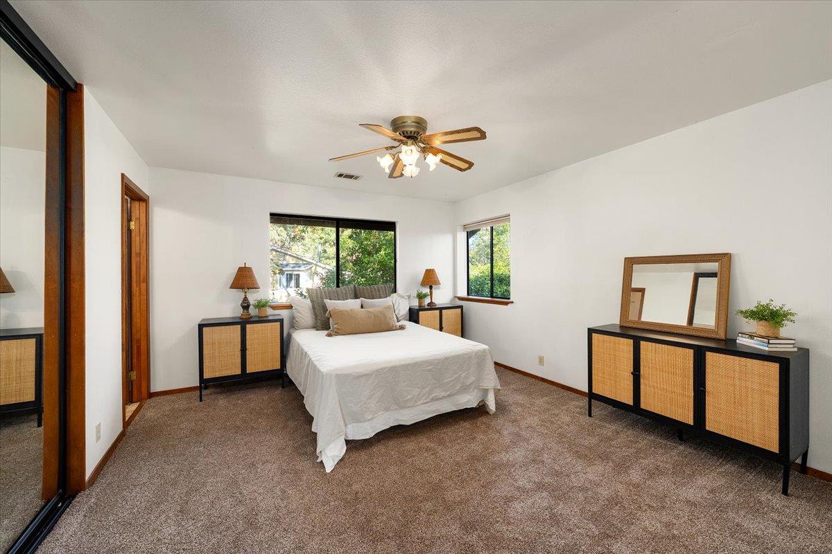 155 Pinewood Way Auburn, CA 95602 - Photo 46 of 92 a spacious bedroom with a bed and a chandelier