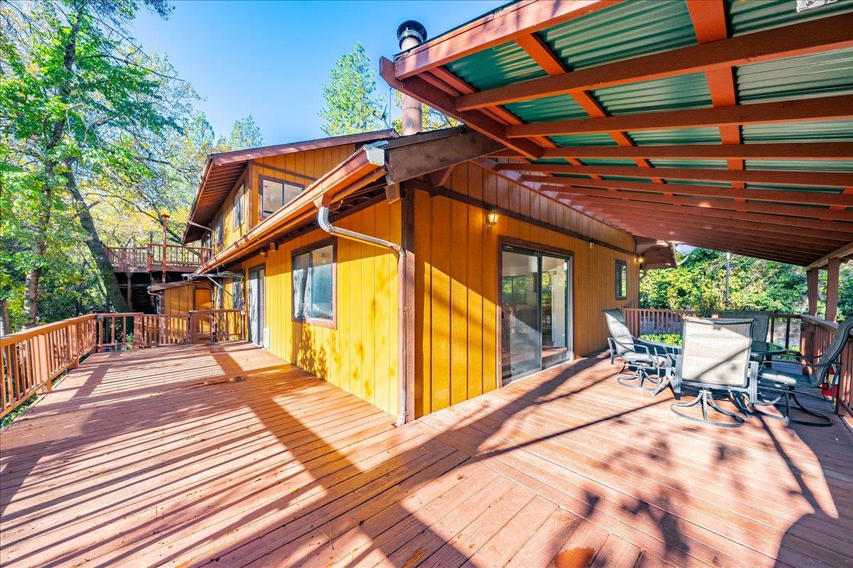 155 Pinewood Way Auburn, CA 95602 - Photo 57 of 92 a view of a patio with table and chairs with wooden floor and fence