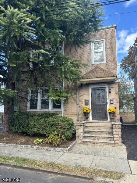 18 Laura Avenue, Unit 1 Nutley, NJ 07110 - Photo 2 of 27 a view of a brick house with large windows and a small yard