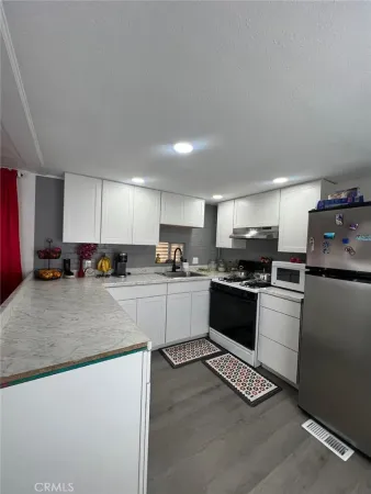 a kitchen with a refrigerator and a stove top oven