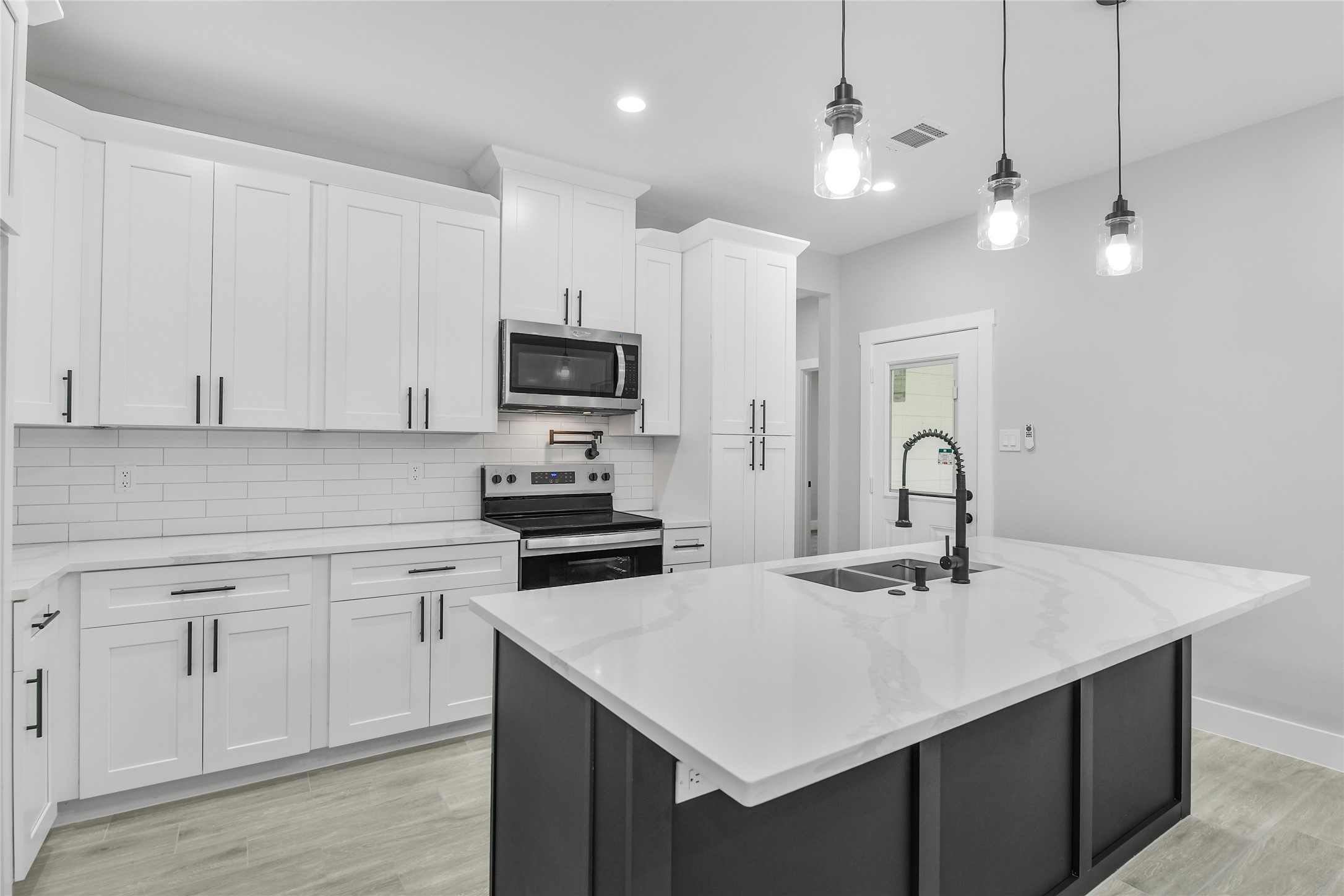 15113 Austin Road Willis, TX 77378 - Photo 11 of 37 a kitchen with kitchen island a sink white cabinets and stainless steel appliances