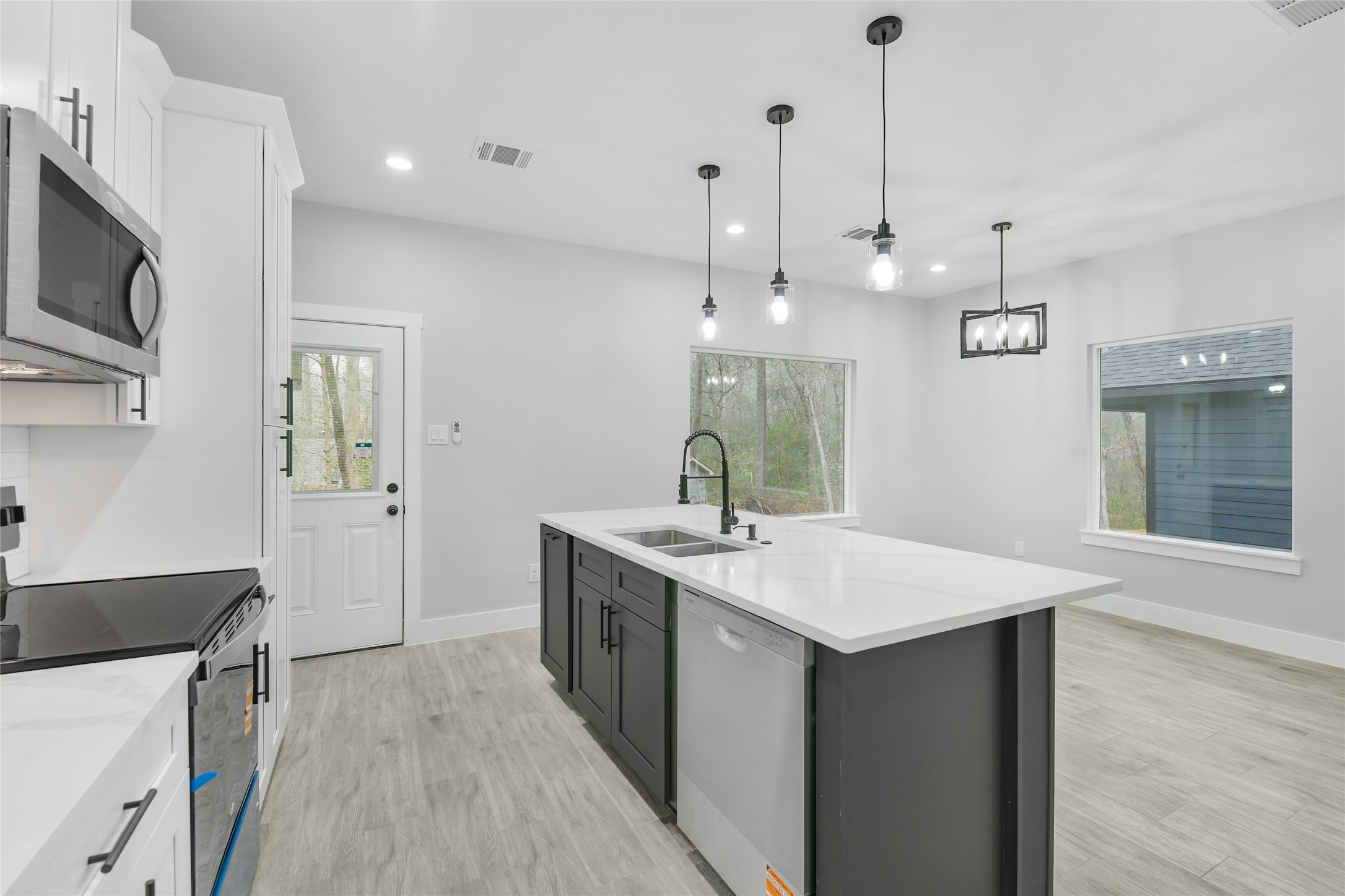 15113 Austin Road Willis, TX 77378 - Photo 13 of 37 a kitchen with a sink a microwave and wooden floor