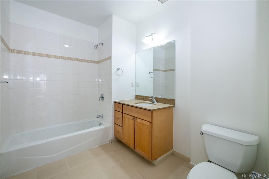 543 Main Street, Unit 410 New Rochelle, NY 10801 - Photo 13 of 24 a bathroom with a granite countertop sink toilet and shower