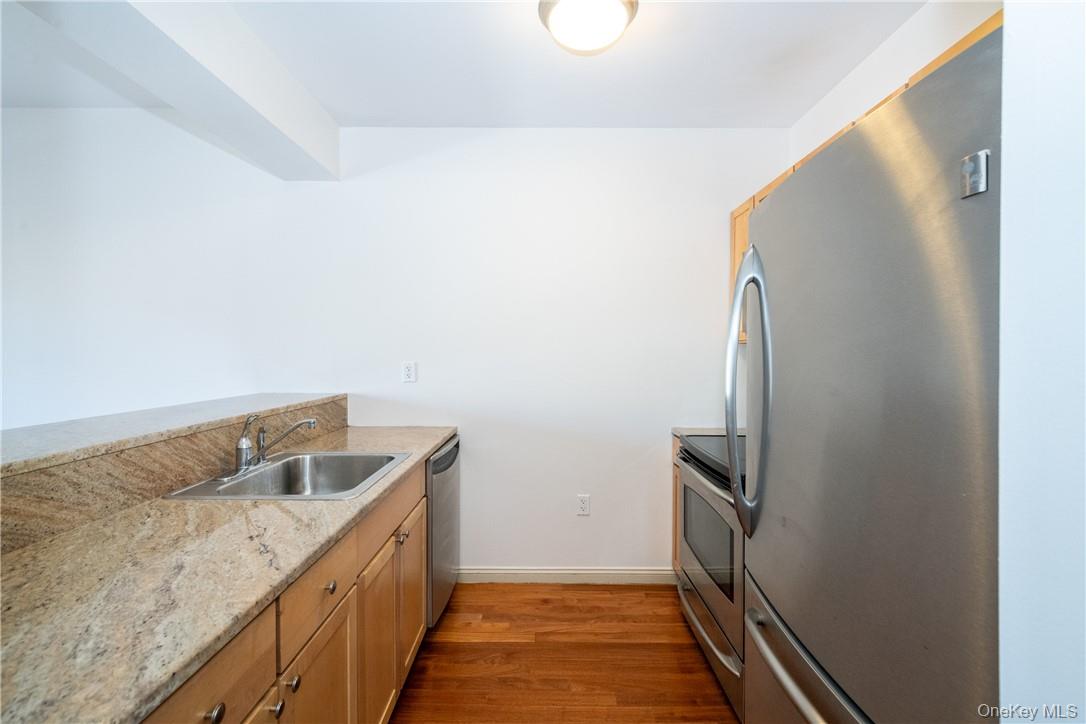 543 Main Street, Unit 410 New Rochelle, NY 10801 - Photo 5 of 24 a kitchen with a refrigerator and a sink