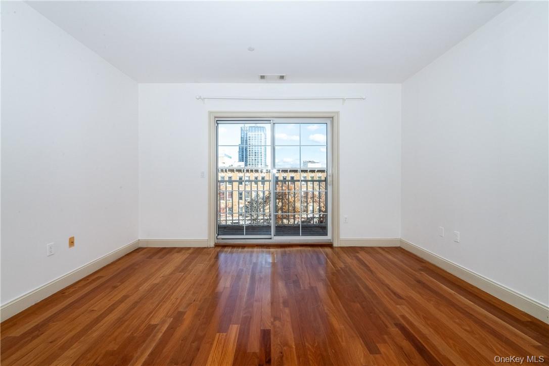 543 Main Street, Unit 410 New Rochelle, NY 10801 - Photo 10 of 24 an empty room with wooden floor and windows