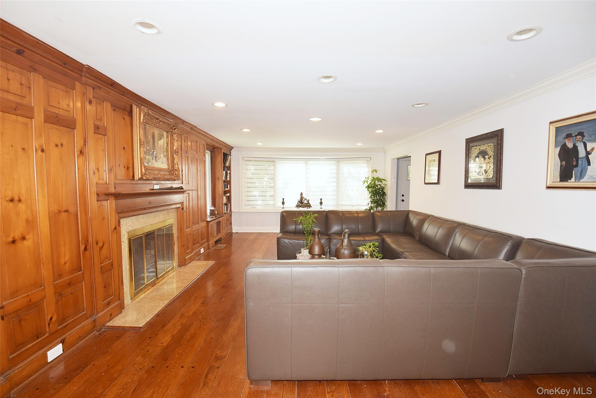 25 Old Mill Road Great Neck, NY 11023 - Photo 25 of 45 Wood-paneled wall with integrated fireplace, rich wood-finish flooring, recessed lighting, and built-in shelving