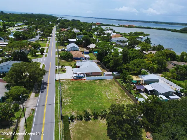 an aerial view of residential houses with outdoor space and trees