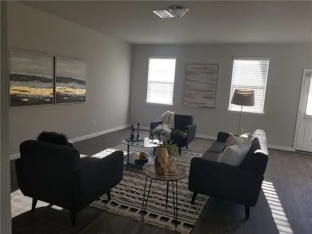 a living room with furniture and wooden floor