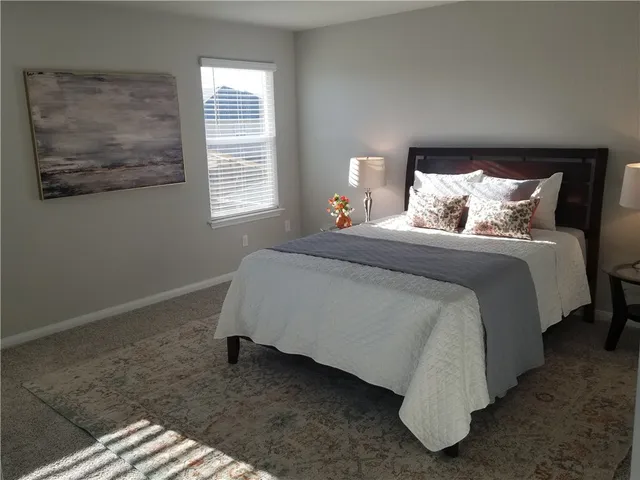 a spacious bedroom with a bed and a window