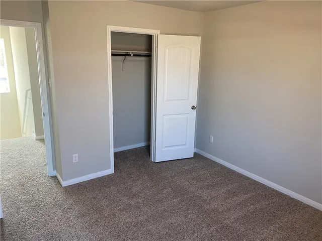 an empty room with closet and a window