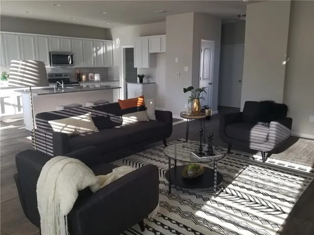 a living room with furniture and a view of kitchen