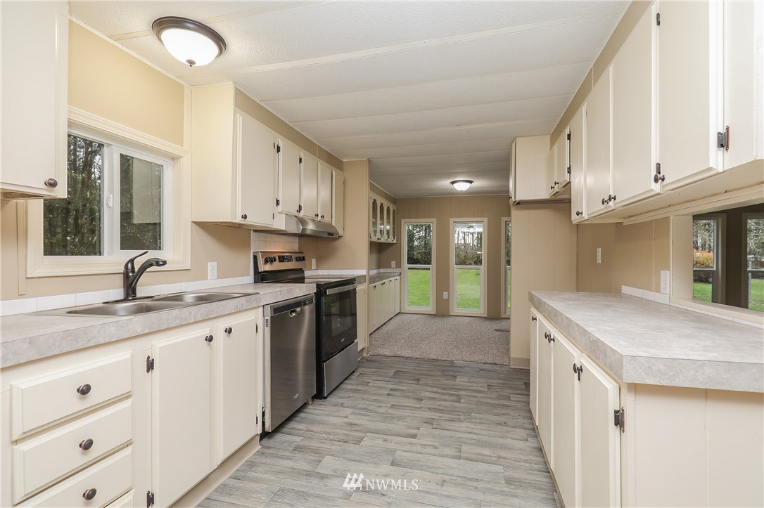 176 Palmer Road Napavine, WA 98532 - Photo 7 of 16 a kitchen with granite countertop white cabinets and white appliances