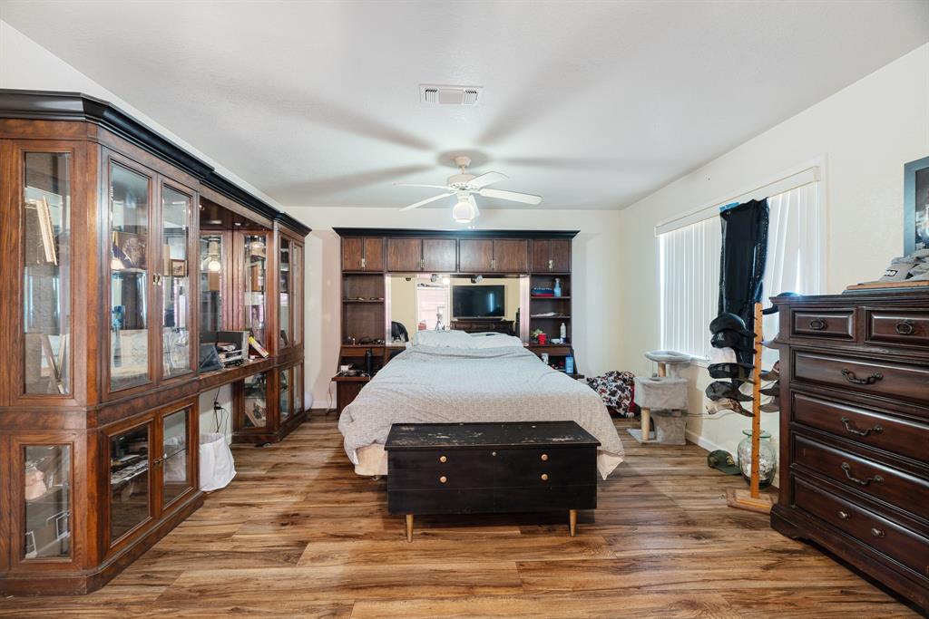 4060 County Road 36220 Sumner, TX 75486 - Photo 13 of 40 a large bedroom with wooden floor and large window