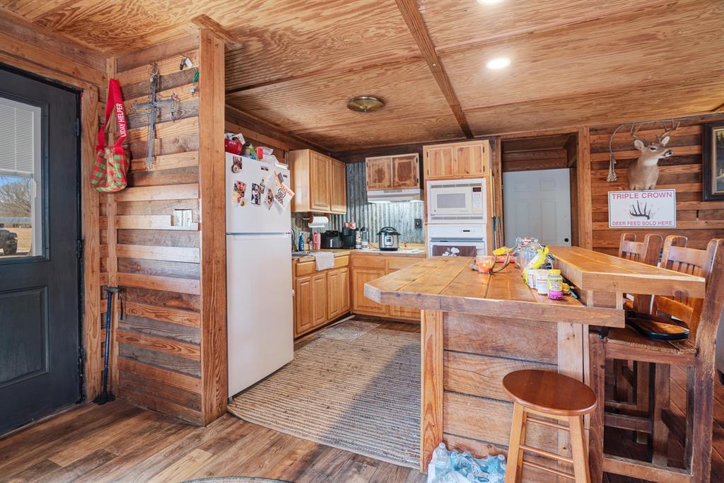4060 County Road 36220 Sumner, TX 75486 - Photo 16 of 40 a kitchen with granite countertop a refrigerator and a stove top oven