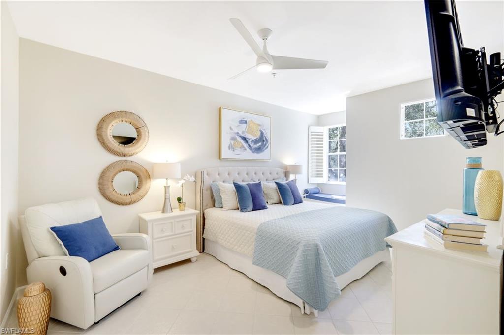 3048 Horizon Lane, Unit 1108 Naples, FL 34109 - Photo 14 of 23 a bedroom with a bed and flat screen tv