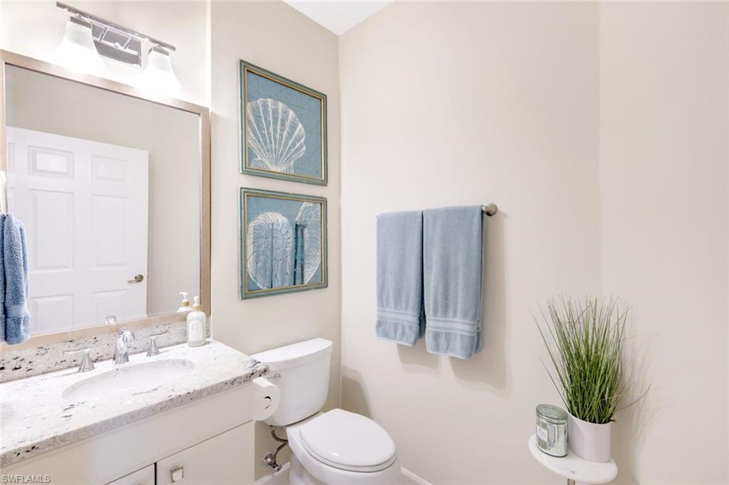 3048 Horizon Lane, Unit 1108 Naples, FL 34109 - Photo 17 of 23 a bathroom with a toilet a sink and mirror