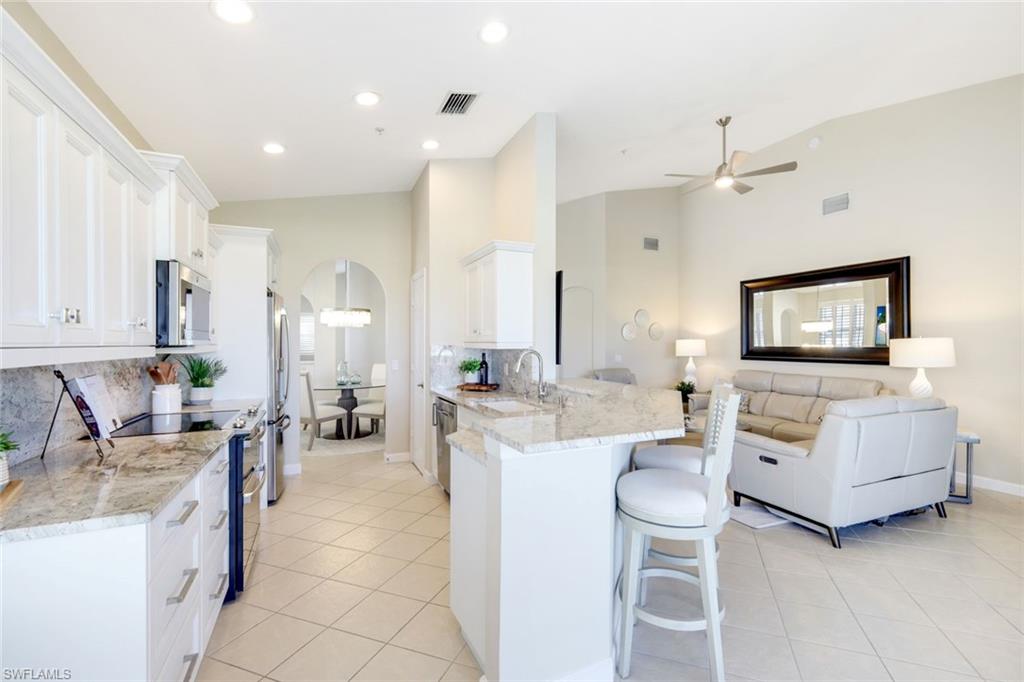 3048 Horizon Lane, Unit 1108 Naples, FL 34109 - Photo 8 of 23 a living room with furniture and a flat screen tv
