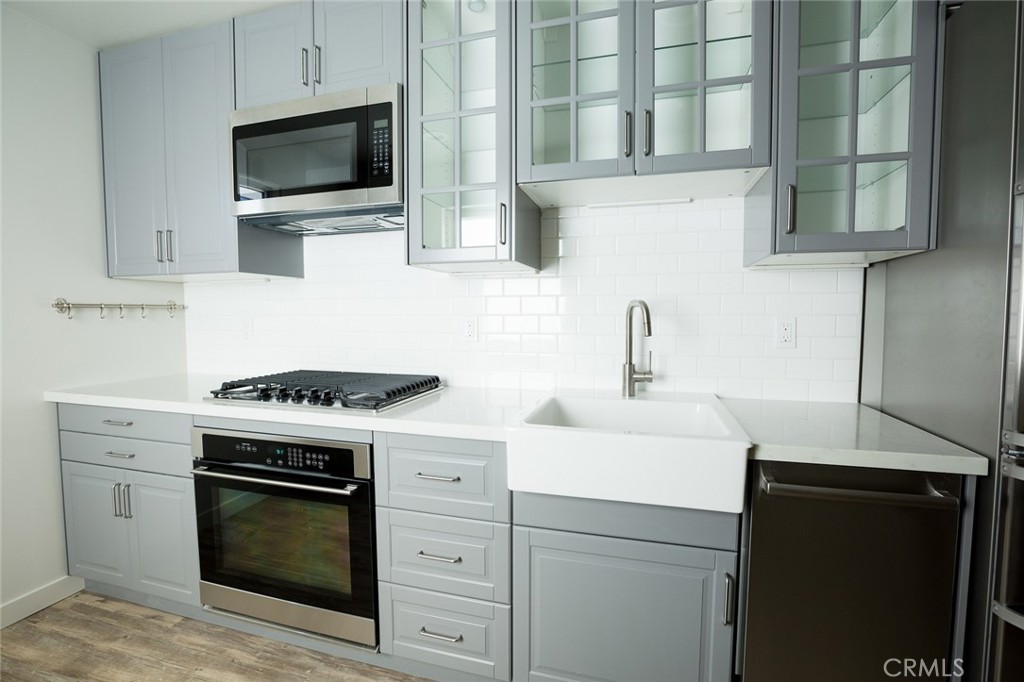 210 Laurel Street, Unit A Avila Beach, CA 93424 - Photo 4 of 16 a kitchen with white cabinets stainless steel appliances and sink