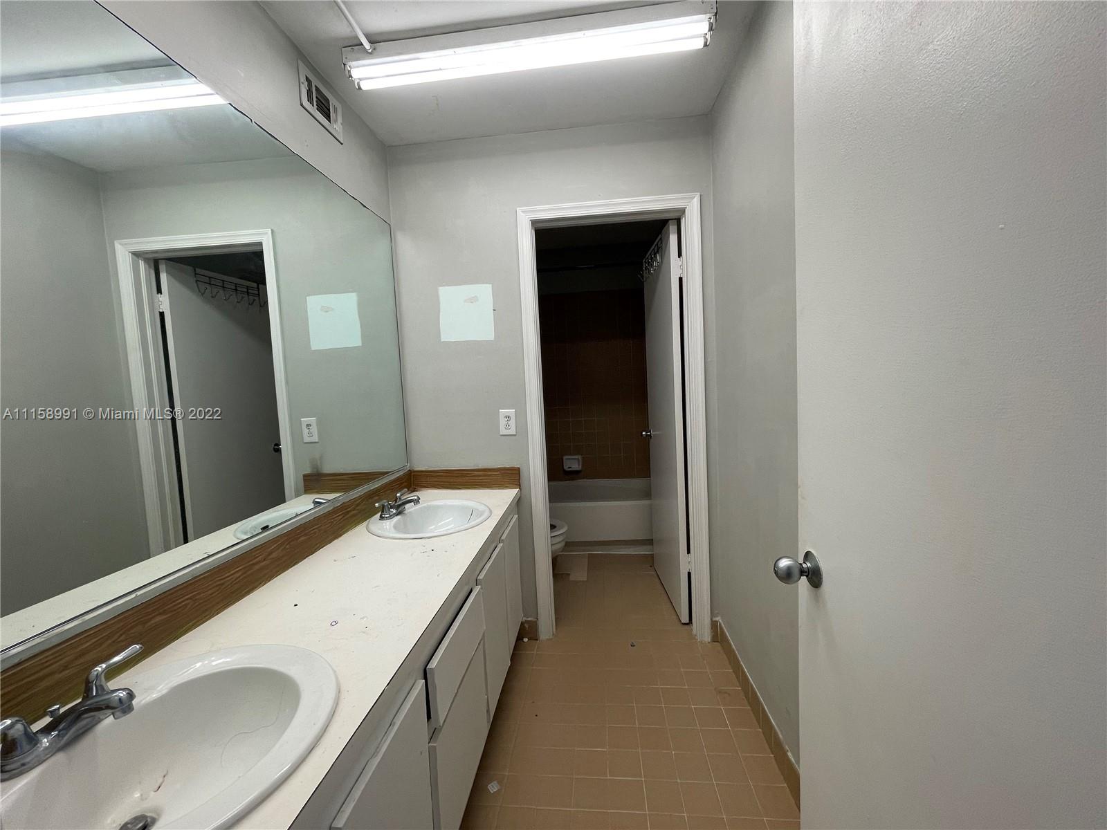 5140 Elmhurst Road, Unit H West Palm Beach, FL 33417 - Photo 12 of 15 a bathroom with a sink and a mirror