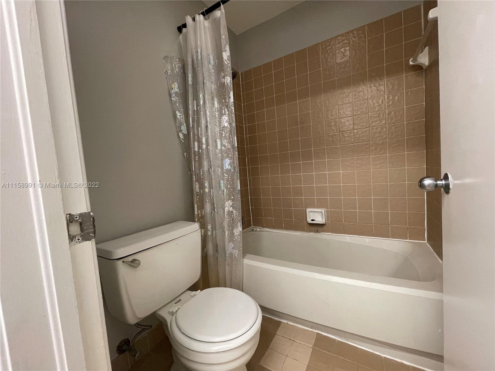 5140 Elmhurst Road, Unit H West Palm Beach, FL 33417 - Photo 13 of 15 a bathroom with a bathtub and a toilet