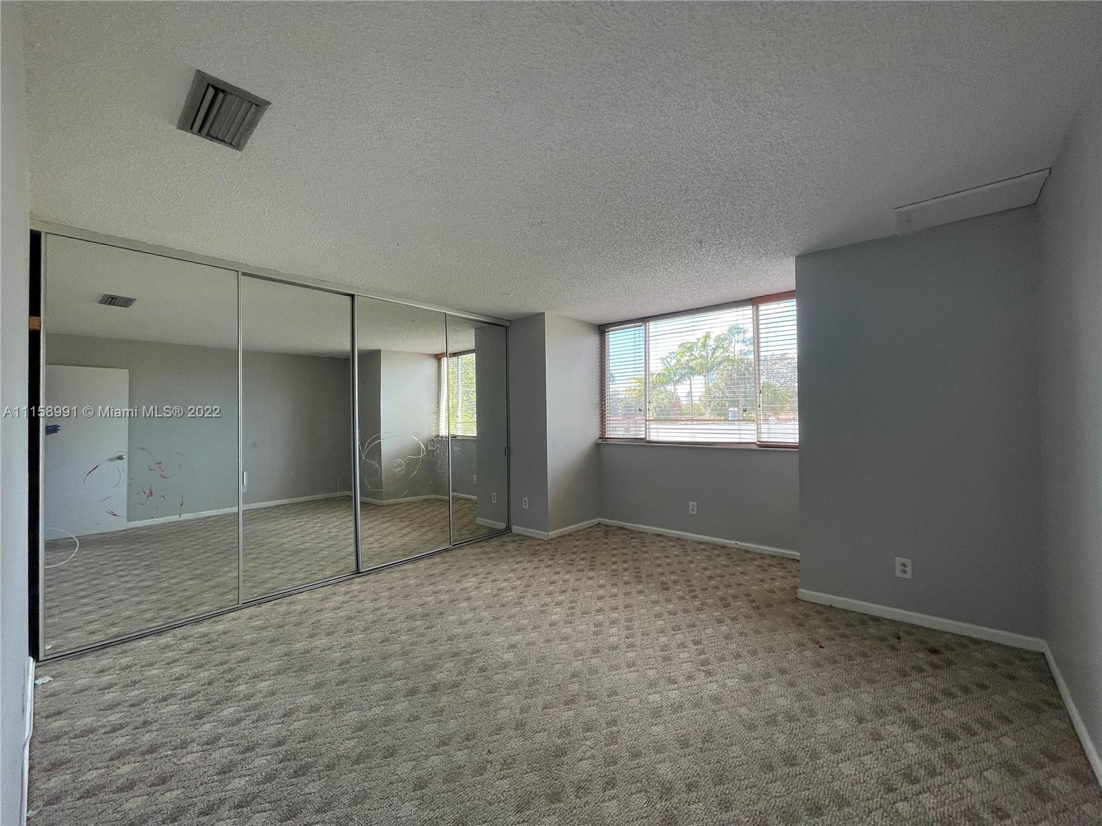 5140 Elmhurst Road, Unit H West Palm Beach, FL 33417 - Photo 14 of 15 a view of an empty room with window and closet area