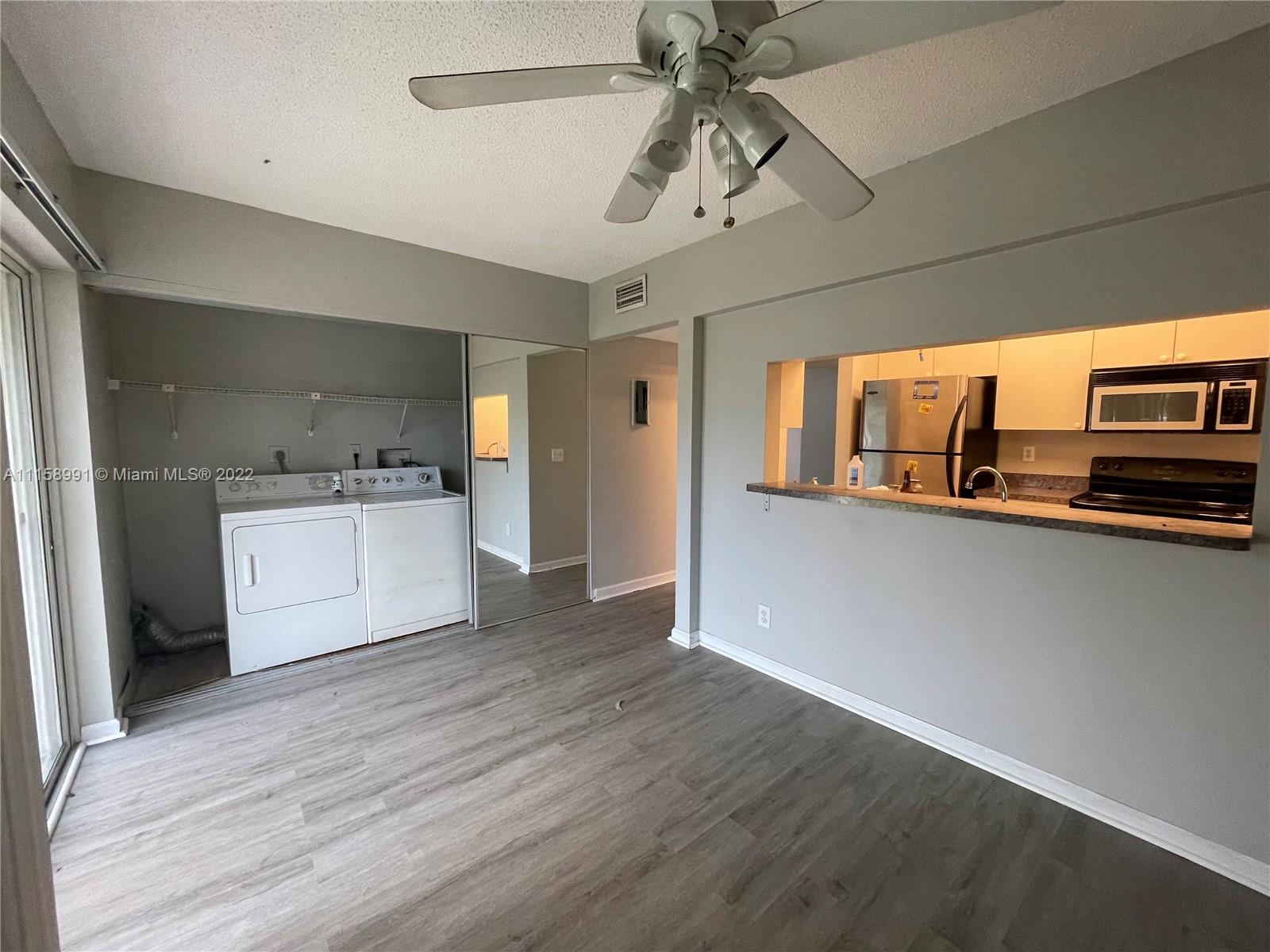 5140 Elmhurst Road, Unit H West Palm Beach, FL 33417 - Photo 5 of 15 a view of a kitchen with a sink and dishwasher wooden floor